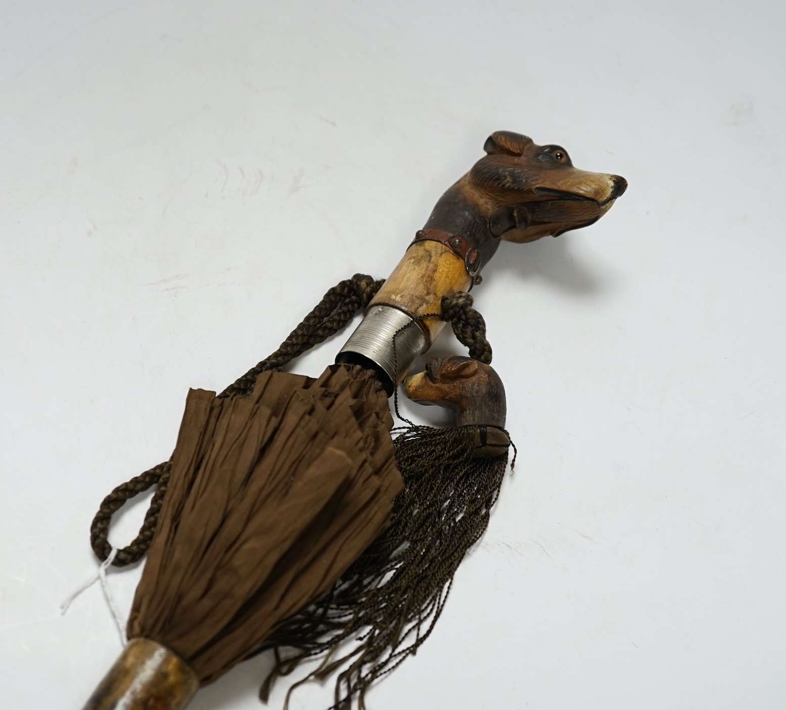 A Victorian silk parasol, carved ‘dogs head’ handle with articulated jaw and telescopic bamboo cover